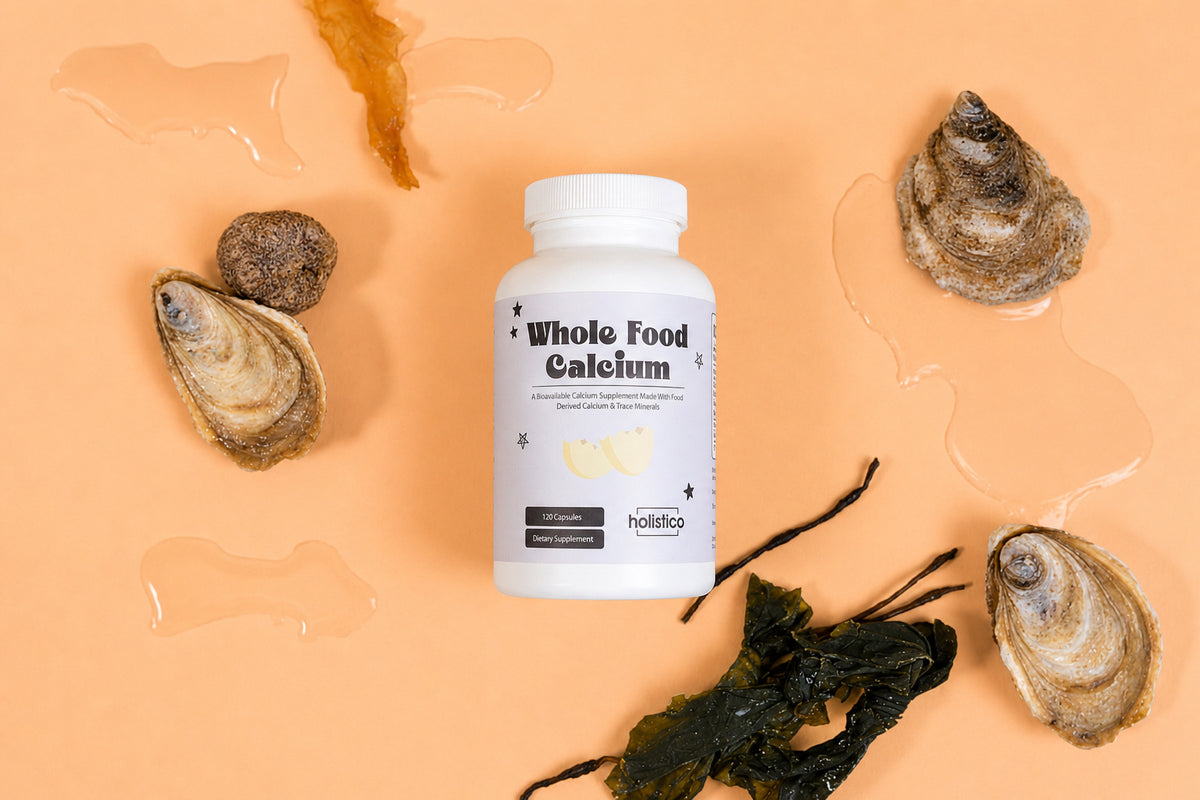 A bottle of Holistico Whole Food Calcium with oysters and seaweed on a peach ground